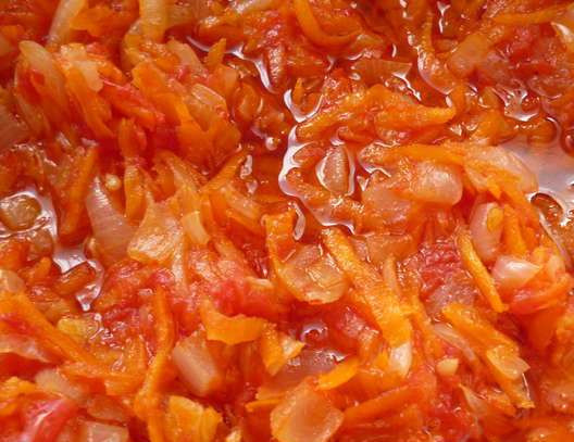 1. Этап. Жаркое с баклажанами и картошкой: Горький перец, помидоры и лук мелко порежьте, морковь потрите на терке. Обжарьте на разогретой сковороде сначала лук, затем добавьте морковь и горький перец. Помешивая обжаривайте несколько минут, затем добавьте помидоры и протушите до испарения половины жидкости. Добавьте измельченный чеснок, посолите и отставьте с огня.