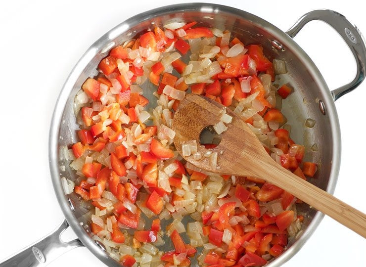 1. Этап. Рис с морепродуктами и овощами: 2. Очистите красный перец от семян и нарежьте его мелким кубиком, выложите в сковороду к луку. Готовьте все 1-2 минуты.