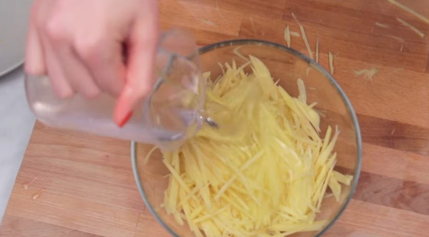 1. Этап. Хрустящая картофельная соломка: 1. Картофель очистите от кожуры и с помощью терки натрите на тонкие полосочки. Затем залейте их холодной водой и оставьте на 10 минут, чтобы картофель отдал немного крахмала.