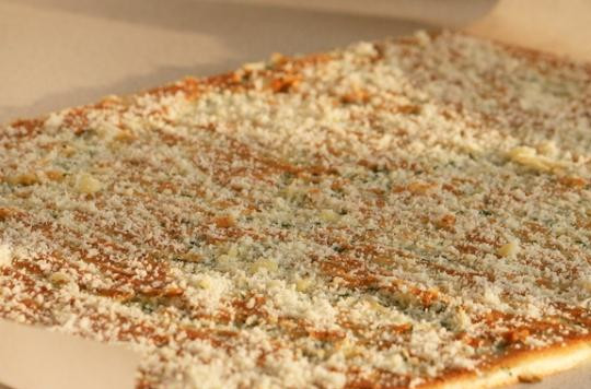 1. Этап. Рулет с семгой и зеленью: Достаем противень из духовки. Коржу даем остыть, пергаментную бумагу, на которой он выпекался, выбрасываем. Посыпаем корж тертым сыром.