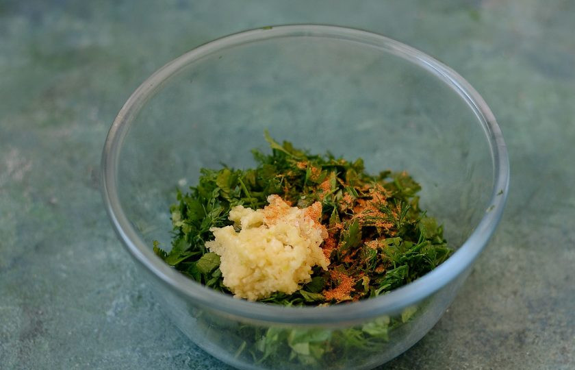 1. Этап. Турша из баклажанов: Чеснок натрите на мелкой терке. Зелень мелко порубите. Добавьте молотый острый перец, перемешайте.