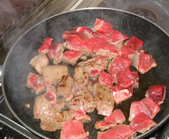 1. Этап. Мясо по-провански: 2. Добавить говядину в сковородку и поджарить. Готовить 6-8 минут, пока мясо не подрумянится, постоянно переворачивая, чтобы мясо поджарилось со всех сторон. Переложить мясо в кастрюлю, влить вино и бульон. Разогреть оставшееся масло в сковородке, добавить лук, готовить на среднем огне 5 минут. Время от времени помешивать, чтобы лук не прилит ко дну сковородки и равномерно приготовился. Добавить морковь и готовить еще 5 минут, пока она не размякнет.