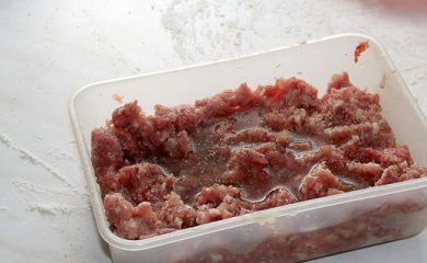 1. Этап. Пельмени из говядины: Добавьте перетертый на блендере чеснок, лук, соль и перец. Вымесите фарш, добавьте водички, чтоб фарш был нежным.