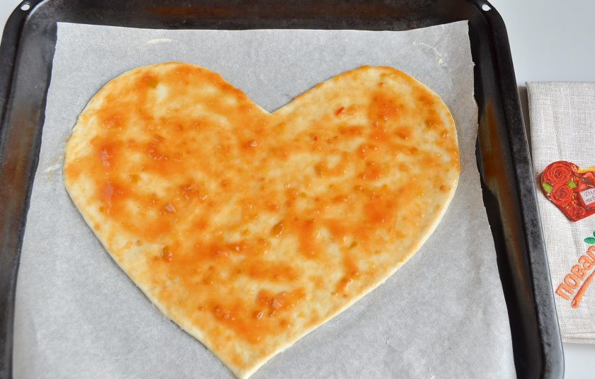 1. Этап. Пицца на 14 февраля: 5. Переместите пергамент на противень. Смажьте пиццу соусом.