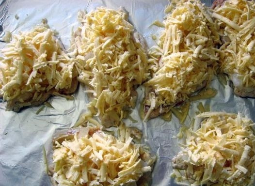 1. Этап. Куриная отбивная с ананасом: 5. Сыр потереть на крупной терке и посыпать отбивные.