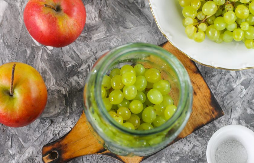 1. Этап. Компот из винограда с яблоками на зиму: Ягоды винограда снимите с кисти, промойте в воде и всыпьте в чистую, промытую емкость.