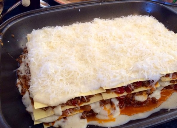 1. Этап. Итальянская лазанья: Постепенно таким же образом выложите все слои лазаньи. Верхний слой смажьте соусом и присыпьте пармезаном. Дайте лазанье постояить минут 15, а затем запеките её в духовке. Время запекания - 25 минут.