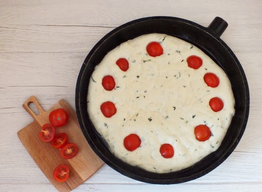 1. Этап. Фокачча в хлебопечке: Включите духовку на 200 градусов. Возьмите черри, разрежьте пополам и вдавите в тесто.