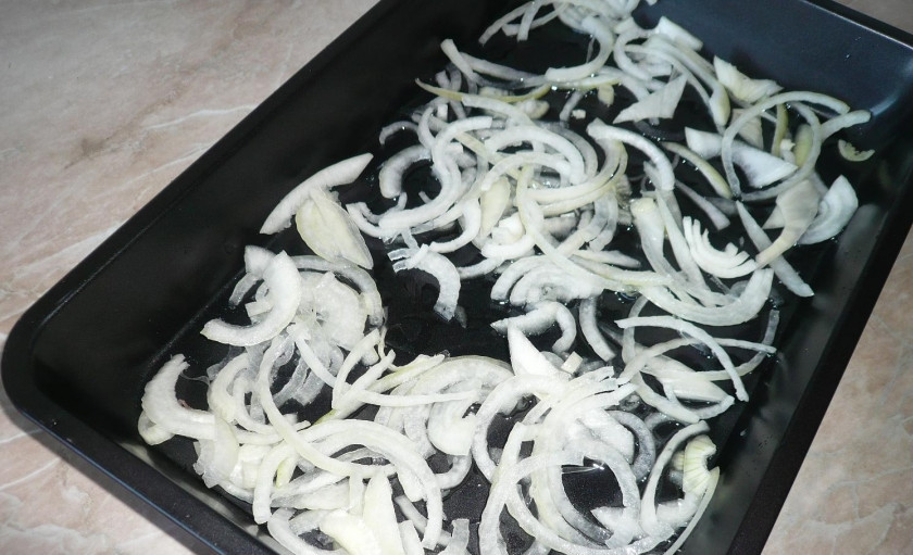 1. Этап. Запеченный картофель со свининой: 1. Лук моем, чистим и нарезаем полукольцами. на дно наливаем немного маслом, затем выкладываем лук.