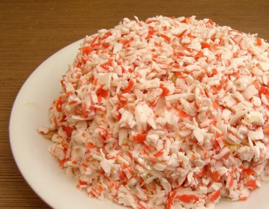 1. Этап. Крабовый салат с плавленым сыром: Посыпаем салат оставшимися натертыми палочками со всех сторон. Верх украшаем по своему желанию.