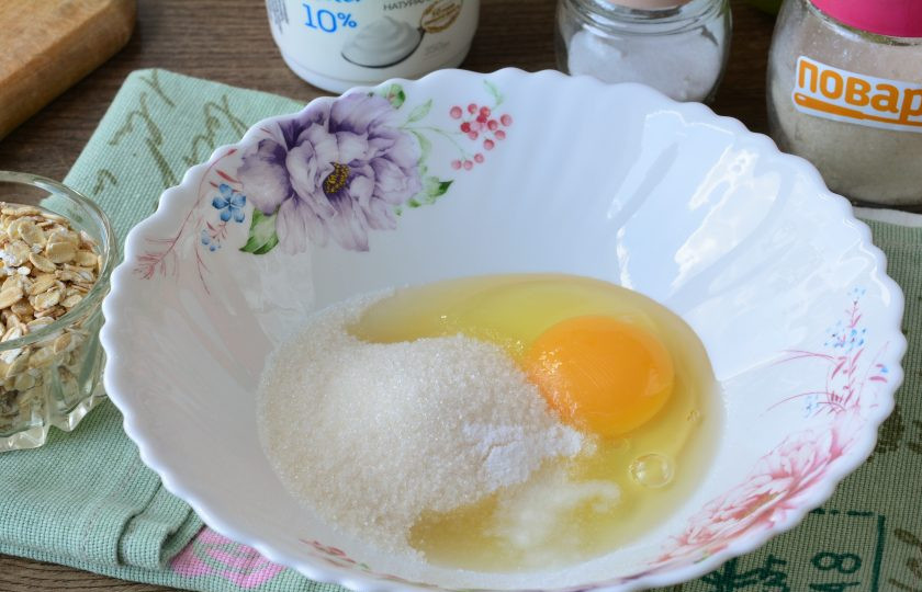 1. Этап. Творожная запеканка с геркулесом и яблоками: Вбейте яйца в глубокую емкость, всыпьте сахар и ванилин, взболтайте венчиком.