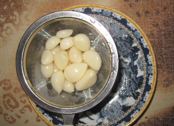 1. Этап. Огурчики Пальчики на зиму: Сложите огурцы в кастрюлю, добавьте к ним порезанную мелко петрушку. Чеснок очистите от шелухи.