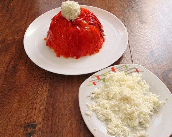 1. Этап. Салат Шапочка Деда Мороза: 9. Оставшиеся яйца разделите на белок и желток. Последний разомните вилкой, добавьте немного майонеза и сформируйте шарик. Готовый бумбон обваляйте в натертом на терке белке и выложите сверху на 