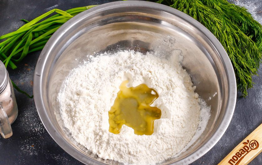 1. Этап. Пита с тунцом: Вскипятите воду в чайнике или в ковше. Всыпьте в глубокую емкость просеянную пшеничную муку. Сделайте в ней углубление и всыпьте соль, влейте растительное масло.