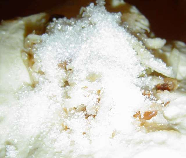 1. Этап. Пирожки с яблоками на сковороде: Далее берем один шарик из теста и растягиваем его руками. Кладем в середину немного начинки, посыпаем ее сахаром и сверху кладем опять начинку.