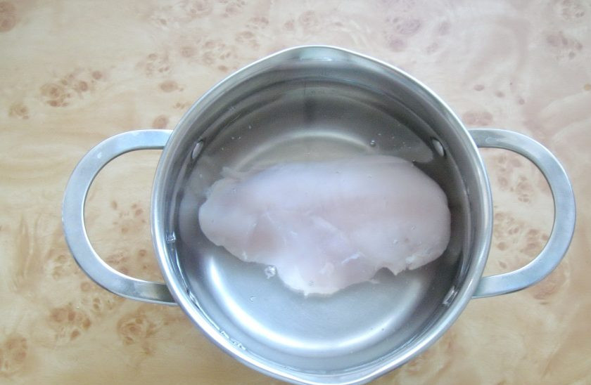 1. Этап. Салат с курицей и лапшой из омлета: Сварите филе куриной грудки. Выложите в кастрюлю и залейте холодной водой. Поставьте на плиту, доведите до кипения, снимите пену и уменьшите огонь до минимума. Варите 20-25 минут.