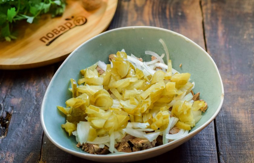 1. Этап. Салат Пассажирский: Маринованные огурцы нарежьте небольшими дольками. Добавьте огурцы в салат.