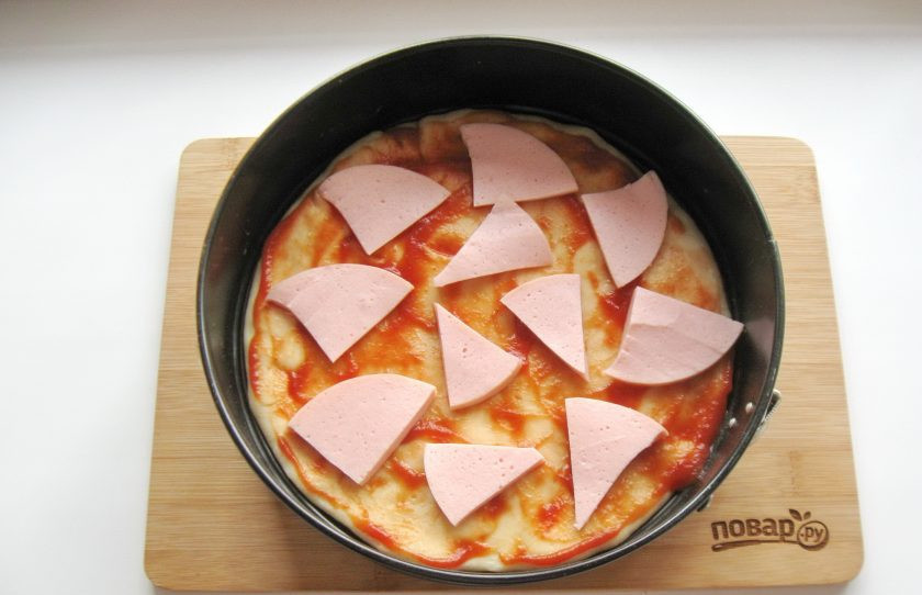 1. Этап. Самая вкусная пицца: Вареную колбасу нарежьте и выложите на тесто.