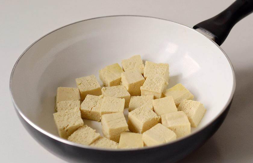 1. Этап. Палак панир с тофу: Разогрейте сковороду на среднем огне. Обжарьте тофу нарезанный кубиками до золотистой корочки. Затем переложите в миску.