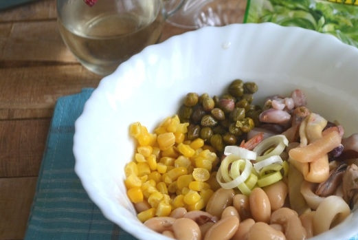 1. Этап. Салат из морепродуктов с фасолью, кукурузой и каперсами: 5. Консервированную фасоль, кукурузу, каперсы соедините в глубокой мисочке. Туда же добавьте морепродукты и лук-порей.