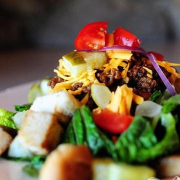 1. Этап. Салат Чизбургер: 6. Добавить нарезанные помидоры, соленые огурцы и кусочки красного лука сверху. Посыпать теплыми гренками и сразу же подавать.