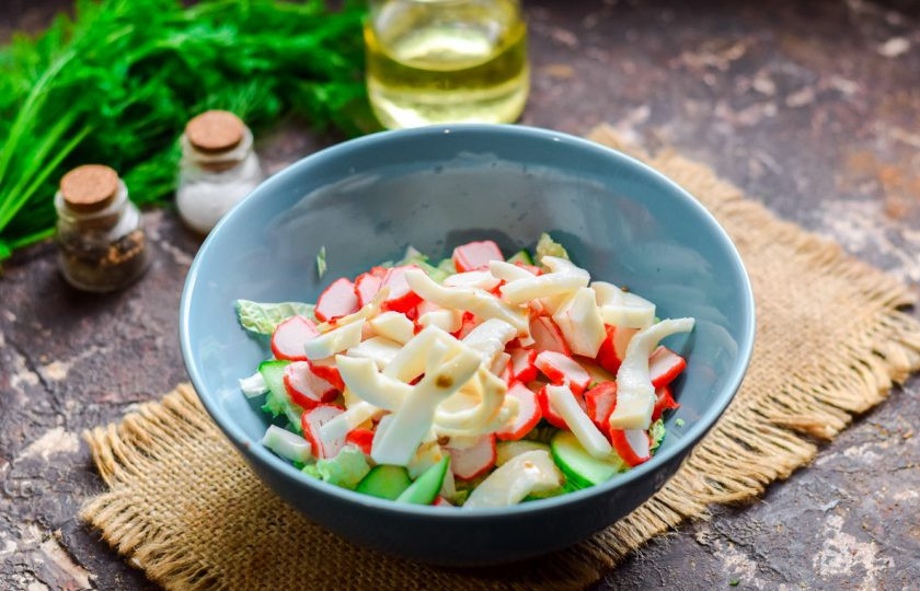 1. Этап. Салат с пекинской капустой, крабовыми палочками и кальмарами: Добавьте в салат нарезанные небольшими кусочками кальмары.