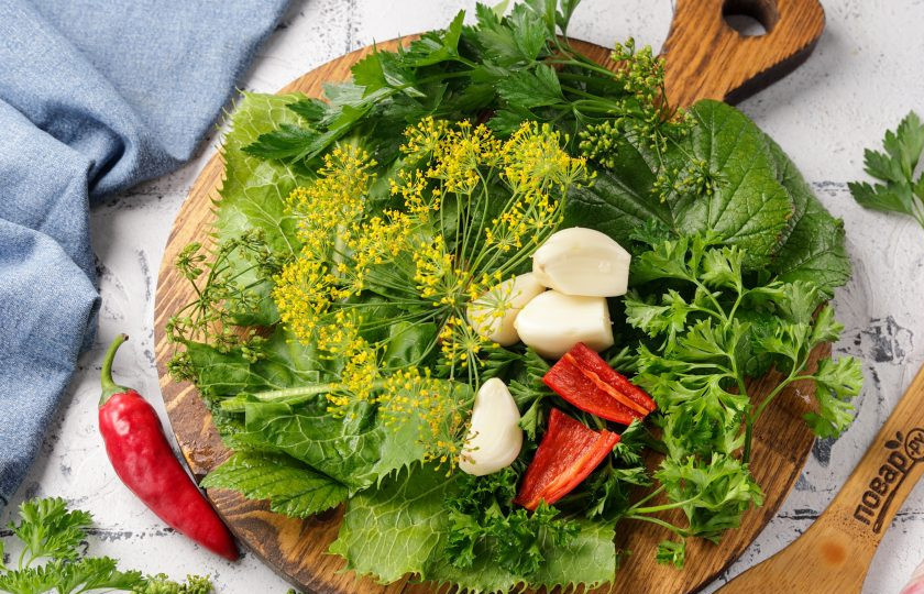 1. Этап. Патиссоны, маринованные кусочками: Зелень промойте. У меня листья хрена, листья смородины, зонтики укропа, веточки петрушки, зелень и семена кориандра. Чеснок очистите от шелухи, половинку острого перца очистите от семян и разрежьте пополам. Если стручок большой или не любите сильно острые закуски, можно добавить на баночку 1-2 колечка.