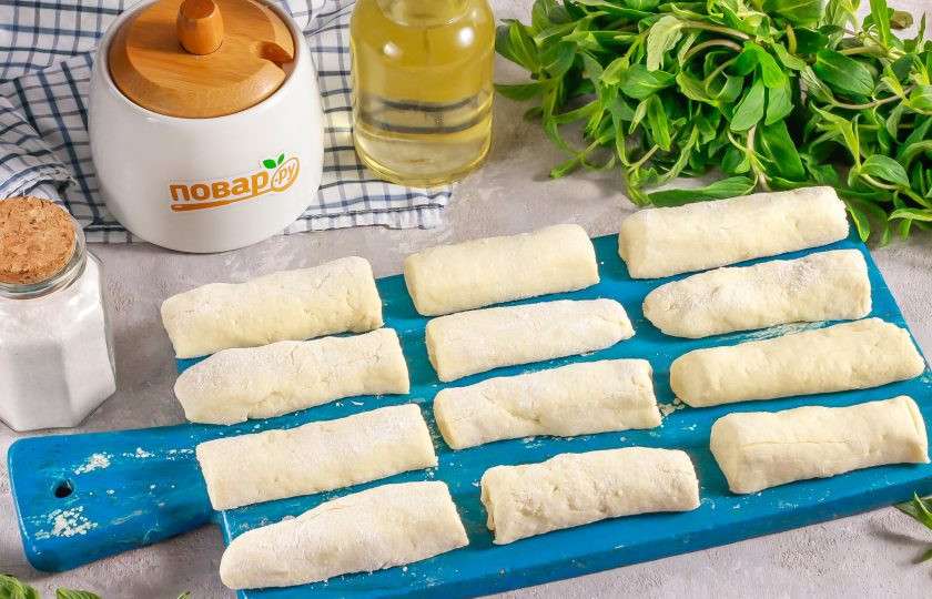 1. Этап. Творожные брусочки: Замесите не слишком крутое тесто и разделите его на части. Каждую из них скатайте на рабочей поверхности в жгут и нарежьте жгут на брусочки длиной примерно 7-8 см. Помните о том, что они еще станут воздушными, пористыми, поэтому толщину делайте поменьше.