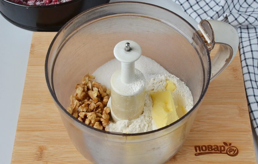 1. Этап. Пирог с клюквой и штрейзельной крошкой: Сделайте штрейльзельную крошку: выложите в комбайн муку, сахар, холодное масло и орехи.