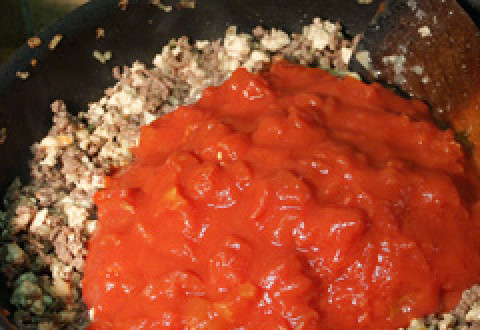 1. Этап. Лазанья с мясом и овощами: В фарш добавьте банку помидор.