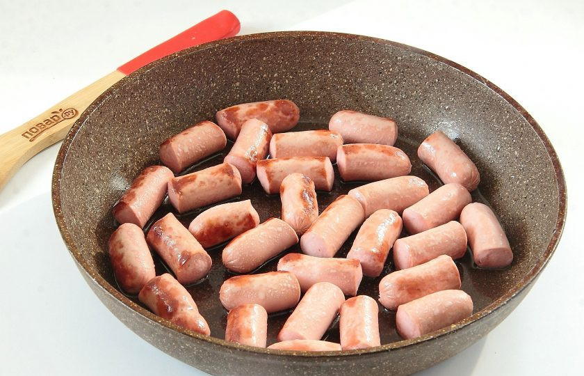 1. Этап. Пирог с колбасками и карамелизированным луком: Нарежьте крупно колбаски и обжарьте их на небольшом количестве растительного масла.