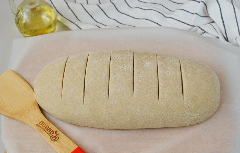 1. Этап. Черный хлеб простой: Сформируйте булку хлеба, выложите на пергамент, острым ножом сделайте надрезы. Накройте полотенцем и оставьте в тепле на 40 минут.