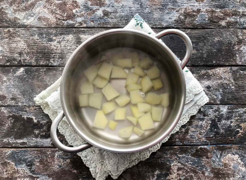 1. Этап. Сырный суп с зеленым горошком: Кастрюлю с водой поставьте на огонь, доведите до кипения и добавьте нарезанный небольшими кусочками картофель и лапшу.