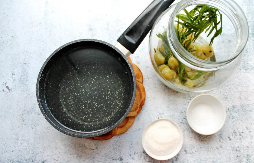 1. Этап. Компот Тархун из крыжовника на зиму: Слейте жидкость в кастрюлю, добавьте сахар и лимонную кислоту. Все перемешайте и доведите до кипения, варите две минуты.