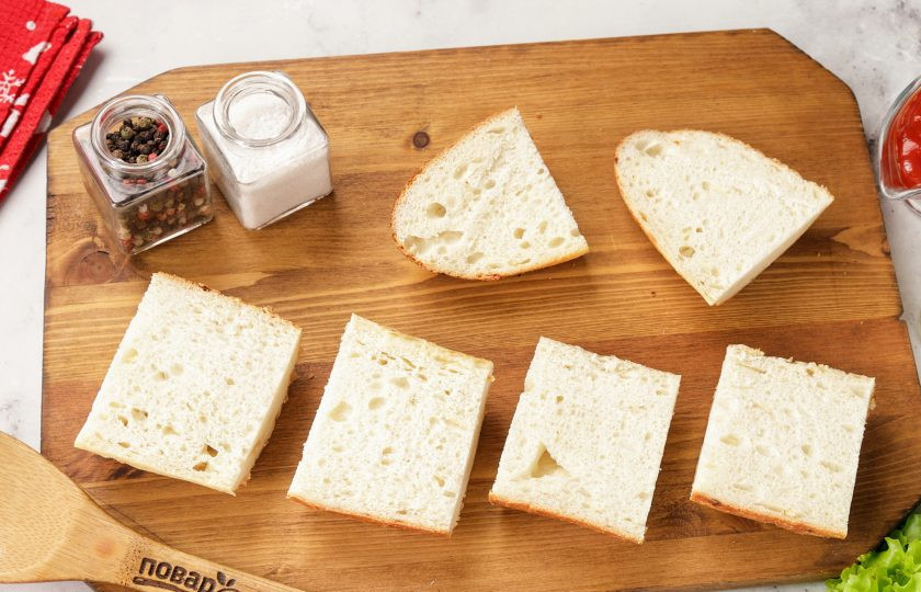 1. Этап. Праздничные бутерброды Змейка: Каждую часть разрежьте вдоль по горизонтали. При желании можно подсушить батон в духовке или на сковороде.