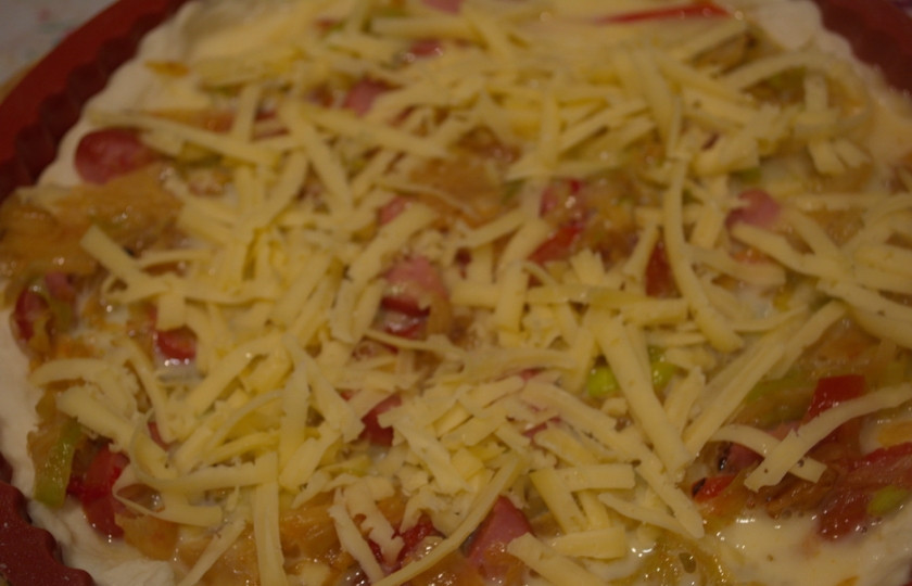 1. Этап. Пирог с капустой и овощами: Натрите твердый сыр. Посыпьте им пирог. Разогрейте духовку до 200 градусов и выпекайте пирог до готовности (20-25 минут).