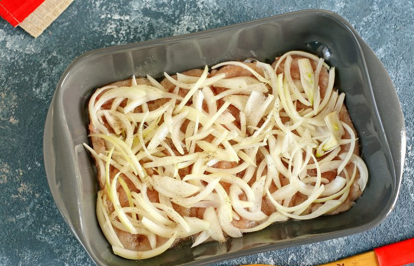 1. Этап. Запеканка из куриной грудки: Сверху выложите нарезанный перьями или кольцами лук. Лук посолите и поперчите.