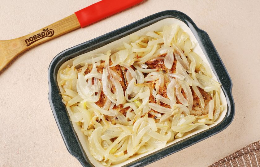 1. Этап. Куриные бёдра в сметанном соусе в духовке: Переложите обжаренные бёдрышки в жаропрочную форму, сверху распределите лук.