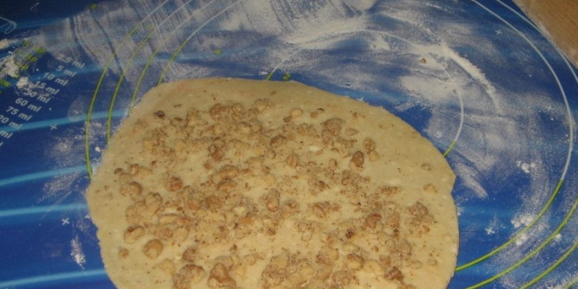 1. Этап. Сыр к пиву в микроволновке: 3. Теперь раскатаем его в тонкий пласт и посыпаем орехами, а затем сворачиваем в рулет.