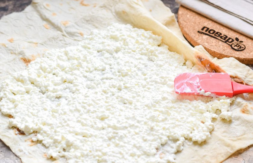 1. Этап. Рулет из лаваша с клубникой и творогом: Смажьте лаваш творогом. Духовку прогрейте до 180 градусов.