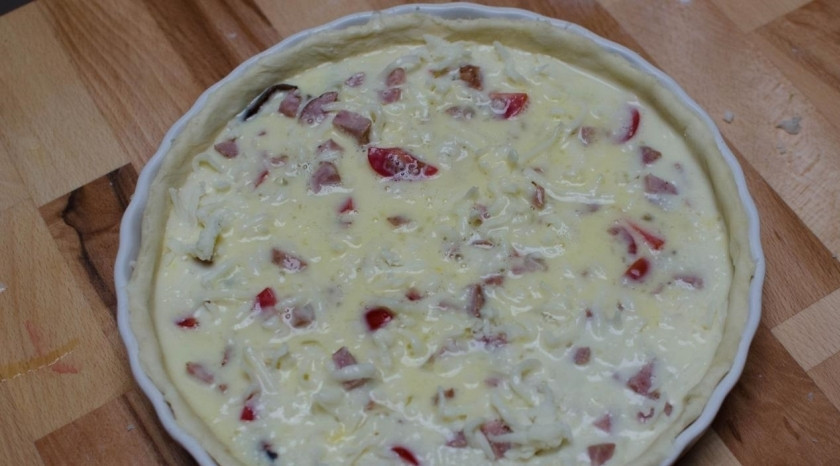 1. Этап. Киш с грибами и сыром: Натрите сыр моцарелла и посыпьте им овощи в основе для киша. Залейте всё взбитыми с молоком яйцами.