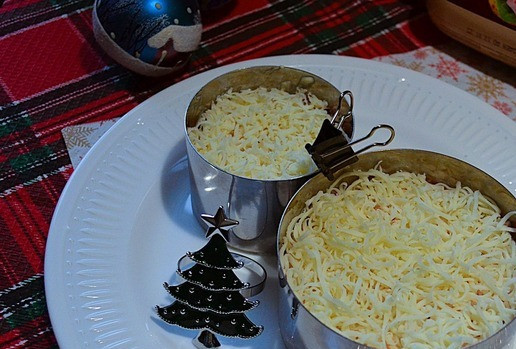 1. Этап. Салат слоёный Снеговик: На мелкой тёрке натереть моцареллу и белок, разложить сверху. Убрать в холодильник на 2-12 часов.