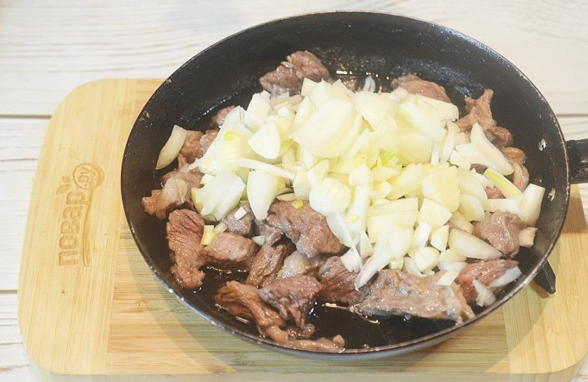 1. Этап. Говядина, тушенная с грибами и бренди-соусом: 5. Добавьте лук и чеснок, обжарьте все вместе.