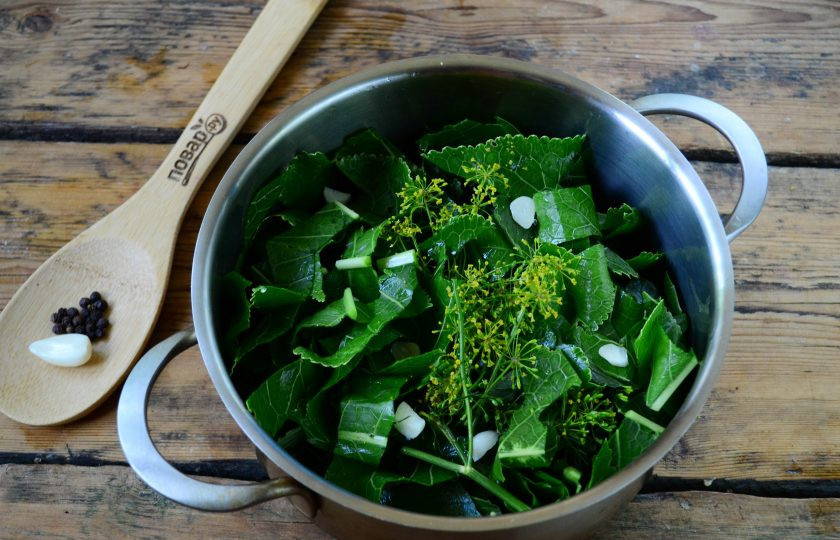 1. Этап. Малосольные огурцы за сутки: Затем снова выложите третью часть зелени, сюда же положите измельченный чеснок и перец горошком.