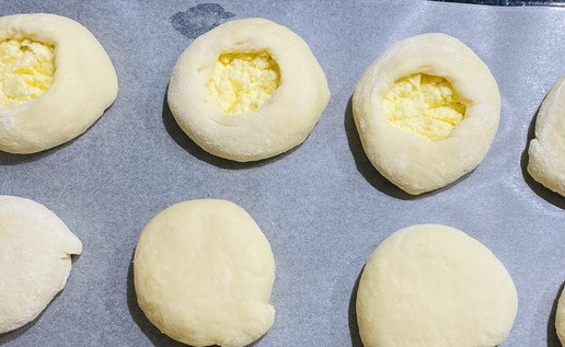 1. Этап. Ватрушки с творогом: Перевернуть швом вниз и руками сформировать круглую заготовку, выложить заготовки на противень, острым ножом сделать отверстие помогая пальцем