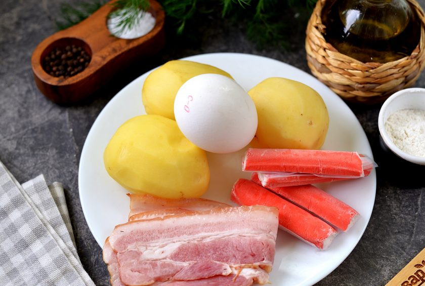 1. Этап. Драники с беконом и крабовыми палочками: Подготовьте все необходимые ингредиенты. Картофель почистите от кожуры, помойте, разморозьте крабовые палочки.