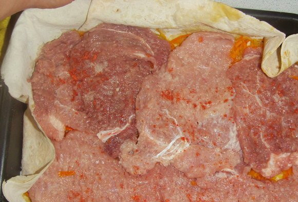 1. Этап. Мясо в лаваше в духовке: Противень слегка смазываем растительным маслом и застилаем лавашом. Выкладываем равномерно слой моркови с луком, сверху выкладываем отбитое мясо. Затем посыпаем всё тёртым сыром.