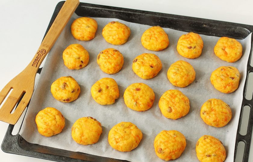 1. Этап. Постное печенье с изюмом: Разделите тесто на 20 частей. Каждый кусочек скатайте шариком и переложите на противень застеленный пергаментом. Затем сверху прижмите заготовки рукой или вилкой. Выпекайте в духовке при температуре 200 градусов около 20 минут.