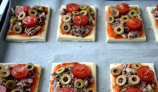 1. Этап. Слойки с консервированным тунцом: Оливки нарезаем колечками распределяем по кусочкам.