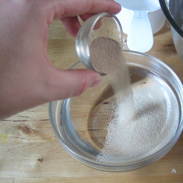 1. Этап. Пицца по-домашнему: В небольшую мисочку наливаем полторы чашки горячей воды. Горячей, но ни в коем случае не кипящей! Кипящая вода убивает дрожжи. Нам нужна горячая вода - приблизительно такой температуры, какую может терпеть ваша рука. Засыпаем в мисочку с горячей водой дрожжи.